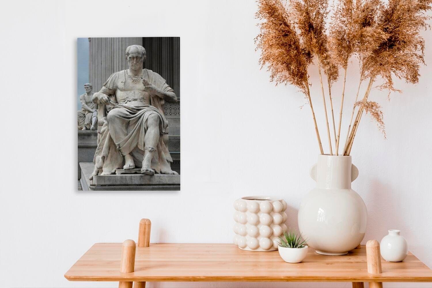 OneMillionCanvasses® Leinwandbild Eine cm Zackenaufhänger, sitzend, von Leinwandbild St), Julius (1 Statue bespannt 20x30 Caesar fertig inkl. Gemälde