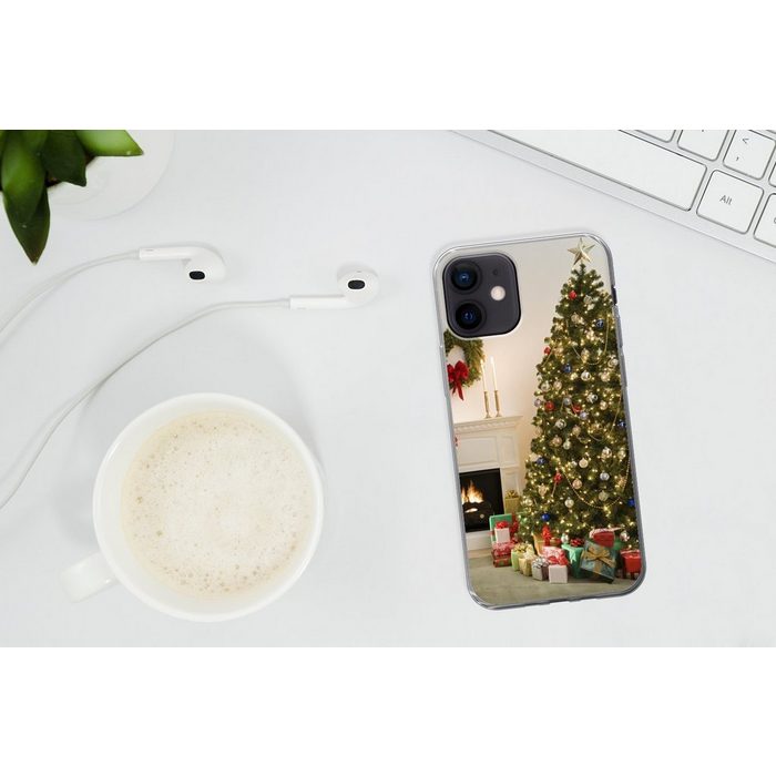 MuchoWow Handyhülle Ein Weihnachtsbaum mit Geschenken neben einem Kamin Handyhülle Apple iPhone 12 Smartphone-Bumper Print Handy ZV11090