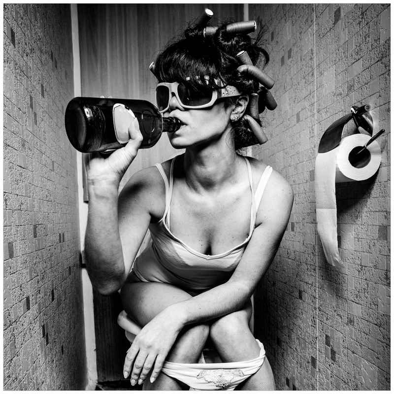 Wallario Glasbild, Kloparty - Sexy Frau auf Toilette mit Weinflasche, in verschiedenen Ausführungen