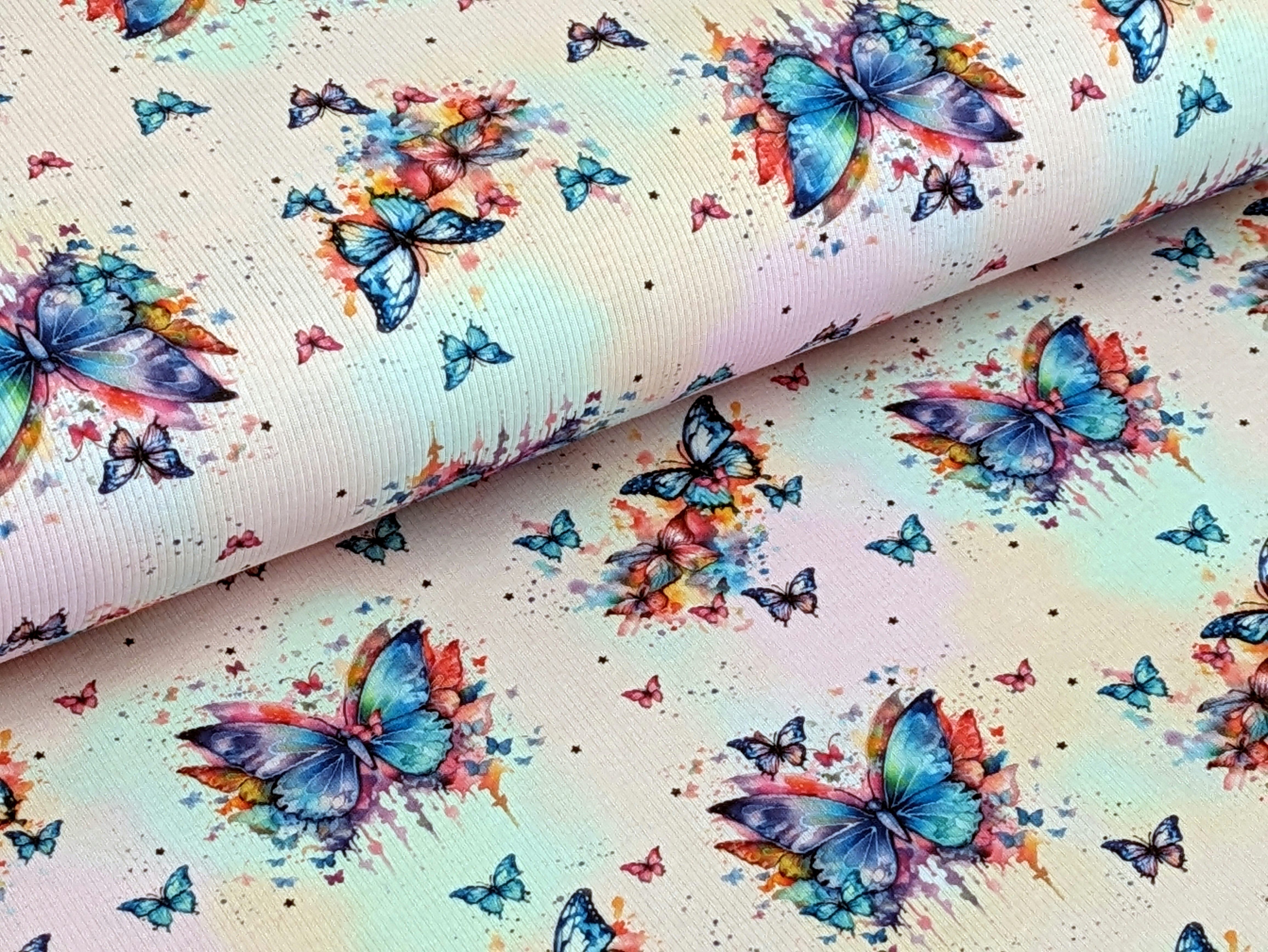 Corileo Stoff Eigenproduktion Rib Jersey Regenbogen Schmetterling auf Hellrosa stoff, Rippenstrucktur