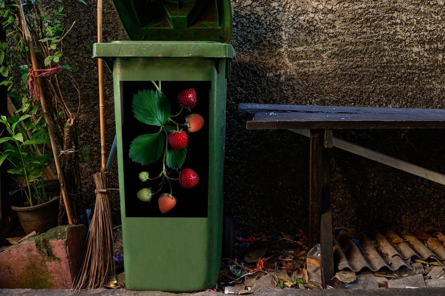 MuchoWow Wandsticker Eine Erdbeerpflanze auf schwarzem Mülltonne, Container, Abfalbehälter Mülleimer-aufkleber, (1 Hintergrund St), Sticker