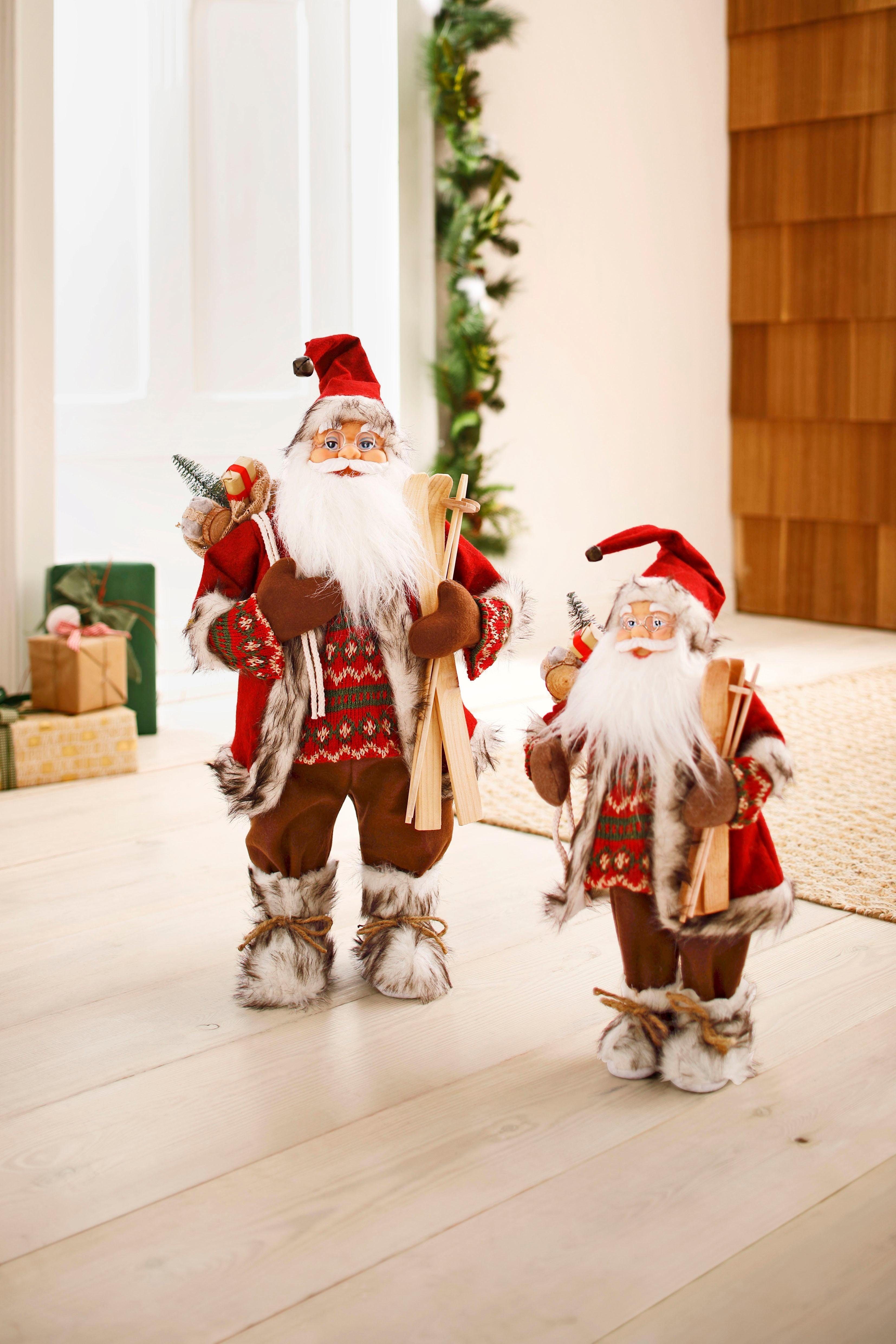 HOMECOLLECTION dem HOSSNER Geschenken Dekofigur, unter St), mit (1 Weihnachtsdeko, - Santa und Skiern Weihnachtsmann Arm Weihnachtsfigur