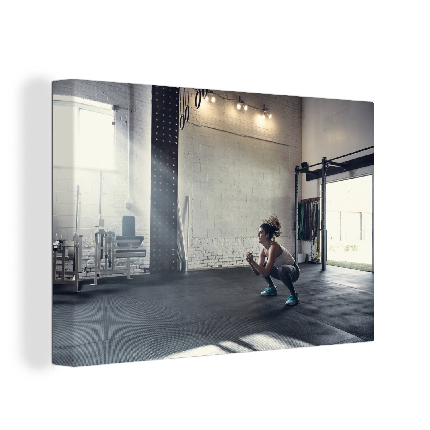 OneMillionCanvasses® Leinwandbild Eine Frau hockt im Fitnessstudio, (1 St), Wandbild Leinwandbilder, Aufhängefertig, Wanddeko, 30x20 cm | Leinwandbilder
