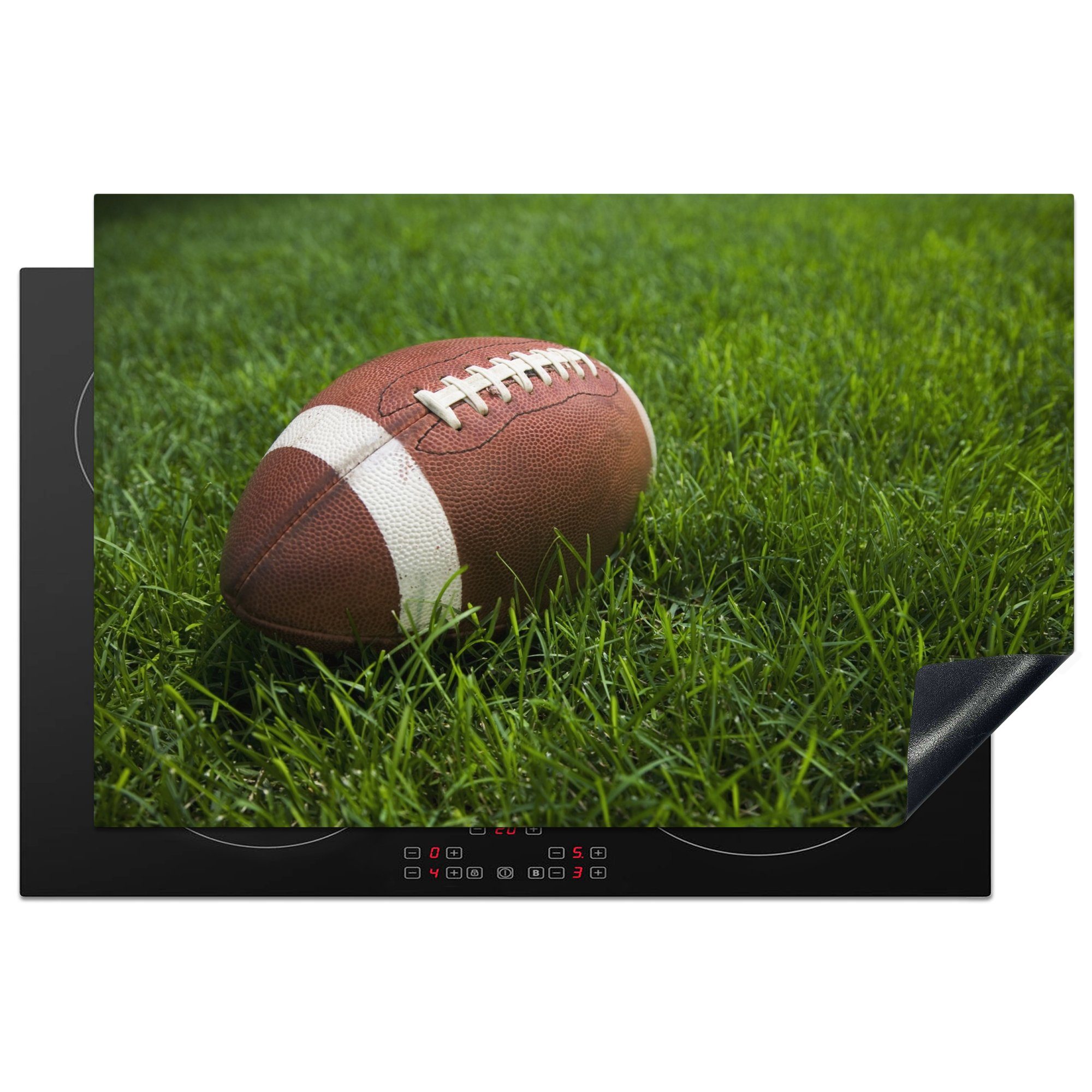 MuchoWow Herdblende-/Abdeckplatte Nahaufnahme eines American Football im grünen Gras, Vinyl, (1 tlg), 81x52 cm, Induktionskochfeld Schutz für die küche, Ceranfeldabdeckung