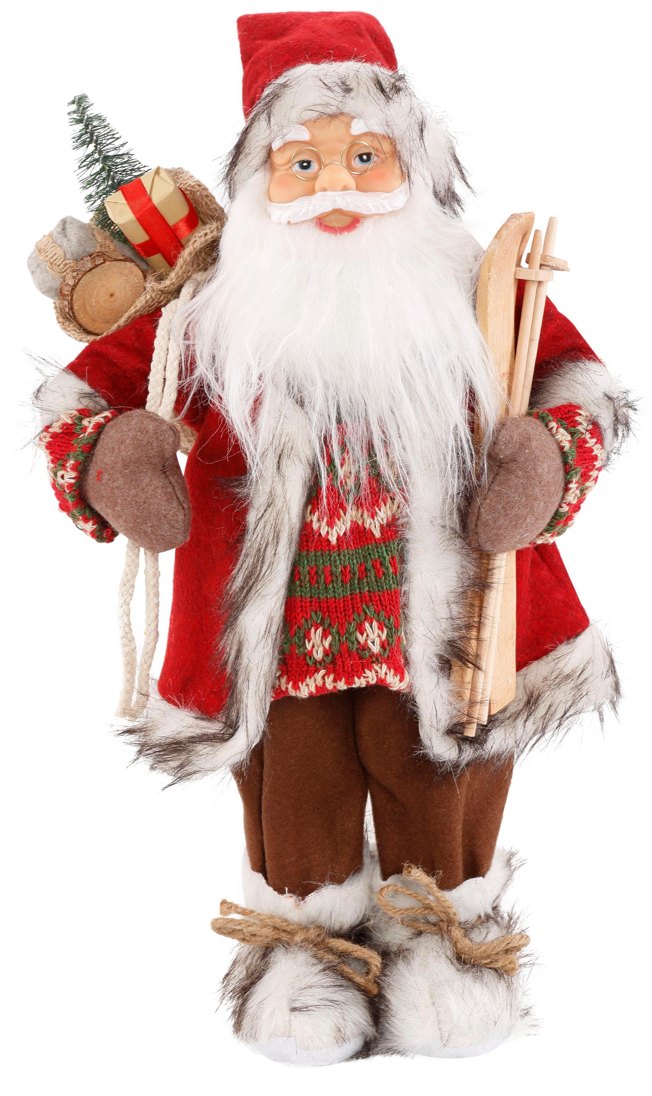 HOSSNER - HOMECOLLECTION Weihnachtsmann Santa mit Skiern unter dem Arm und  Geschenken (1 St), Weihnachtsdeko, Dekofigur, Weihnachtsfigur