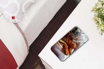 MuchoWow Handyhülle Niedlicher Dackel liegt unter der Bettdecke, Handyhülle Apple iPhone 12 Pro, Smartphone-Bumper, Print, Handy