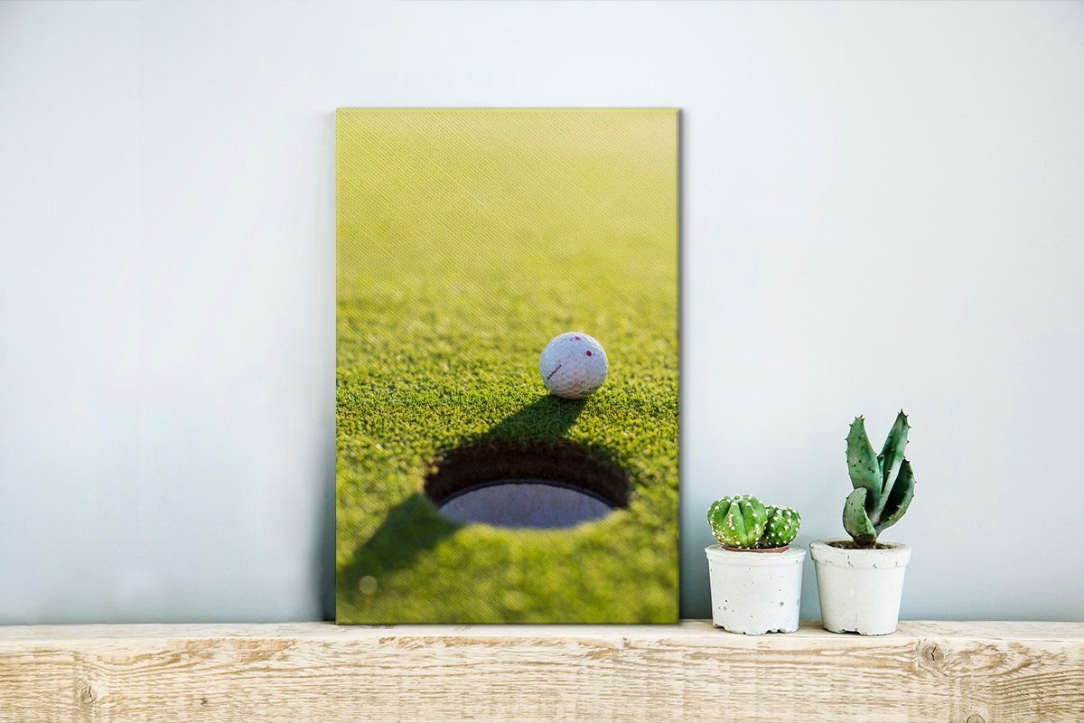 Gras OneMillionCanvasses® im Nähe Lochs, Leinwandbild 20x30 cm fertig des liegt in St), Gemälde, Zackenaufhänger, inkl. (1 Golfball der Leinwandbild bespannt grünen