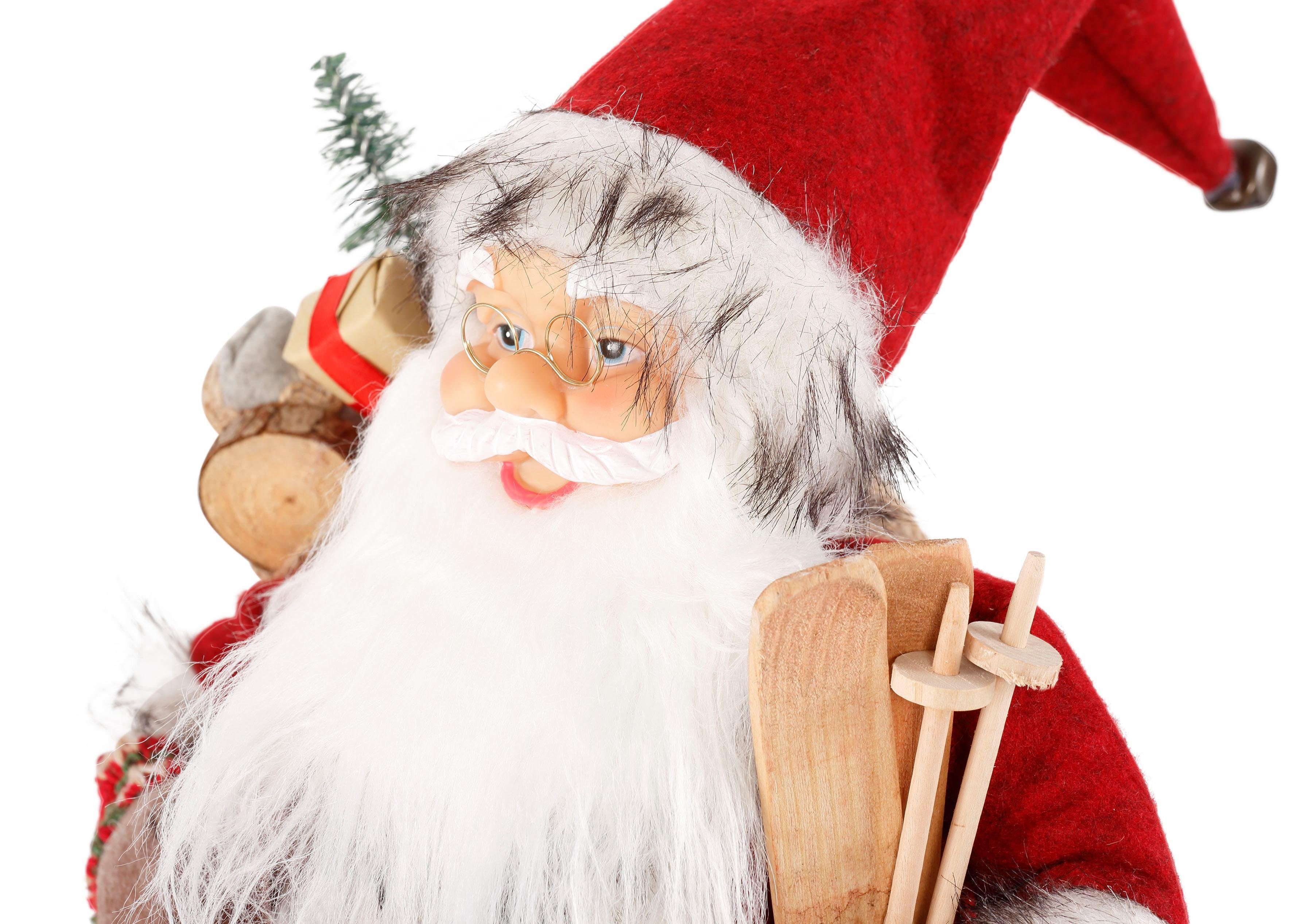 Geschenken und St), Santa Weihnachtsdeko, HOMECOLLECTION - (1 mit unter dem HOSSNER Weihnachtsfigur Weihnachtsmann Skiern Arm Dekofigur,