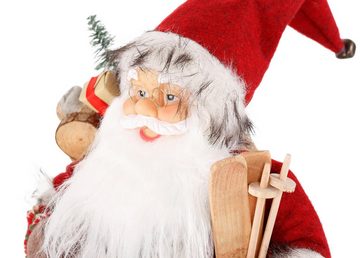 HOSSNER - HOMECOLLECTION Weihnachtsmann Santa mit Skiern unter dem Arm und Geschenken (1 St), Weihnachtsdeko, Dekofigur, Weihnachtsfigur