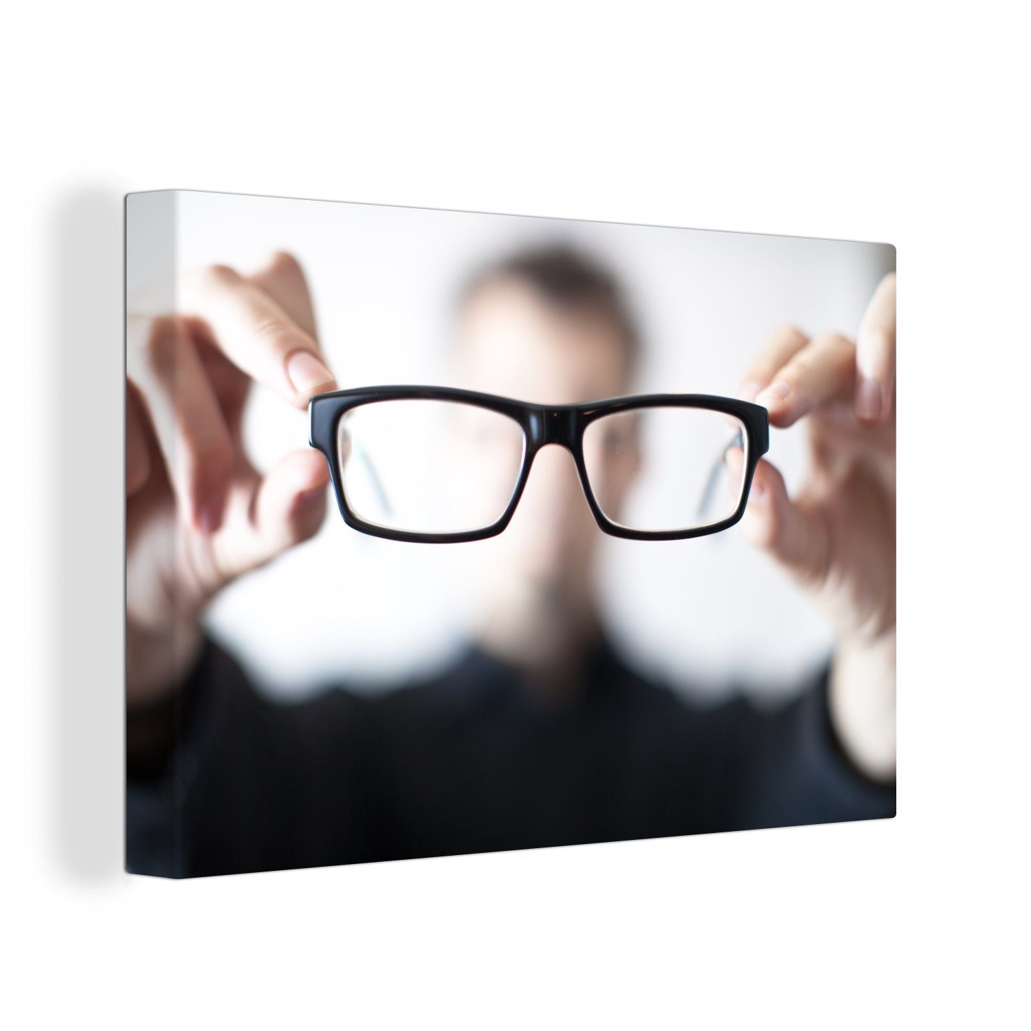 OneMillionCanvasses® Leinwandbild Nahaufnahme Leinwandbilder, Mannes, und der 30x20 eine der Wanddeko, St), (1 Kamera, eines cm Wandbild Brille Aufhängefertig, sie trägt