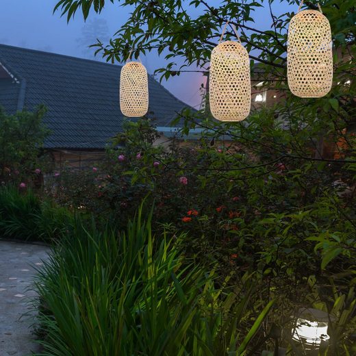 Moderne Solar Hängeleuchte aus Bambus in dreifacher Ausführung hängend am Baum im schönen Garten