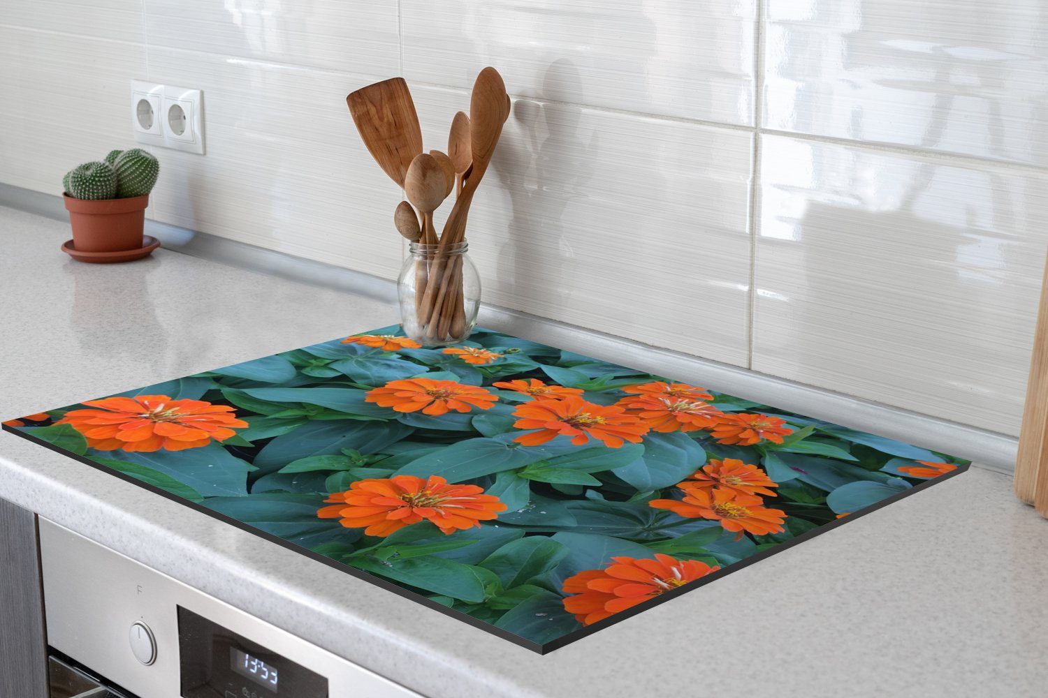 MuchoWow Herdblende-/Abdeckplatte Orangefarbene Zinnienblüten Vinyl, 70x52 Ceranfeldabdeckung grünen cm, mit nutzbar, (1 tlg), Blättern, Arbeitsfläche Mobile