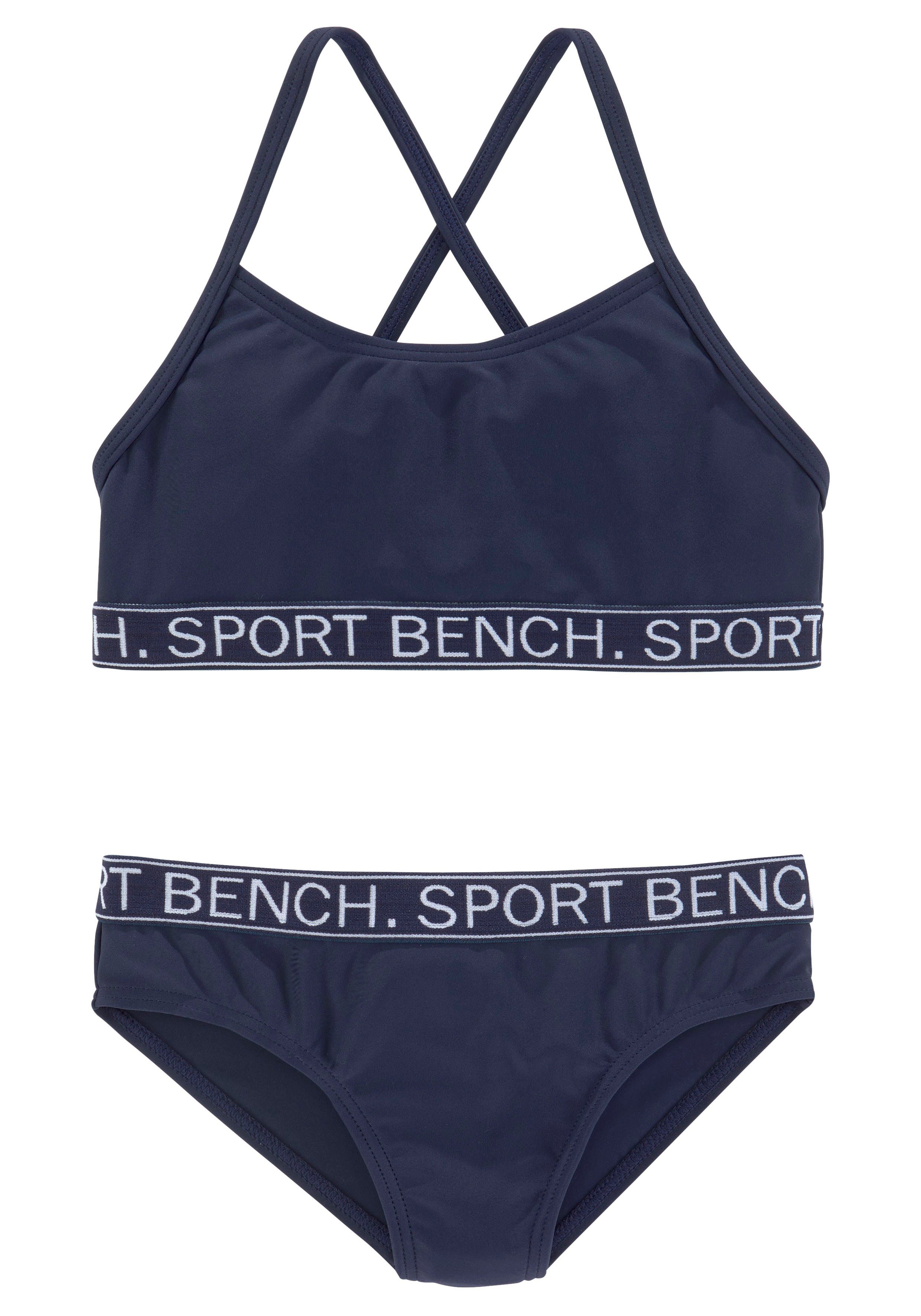 Design Yva in sportlichem Bustier-Bikini und Kids Farben Bench.