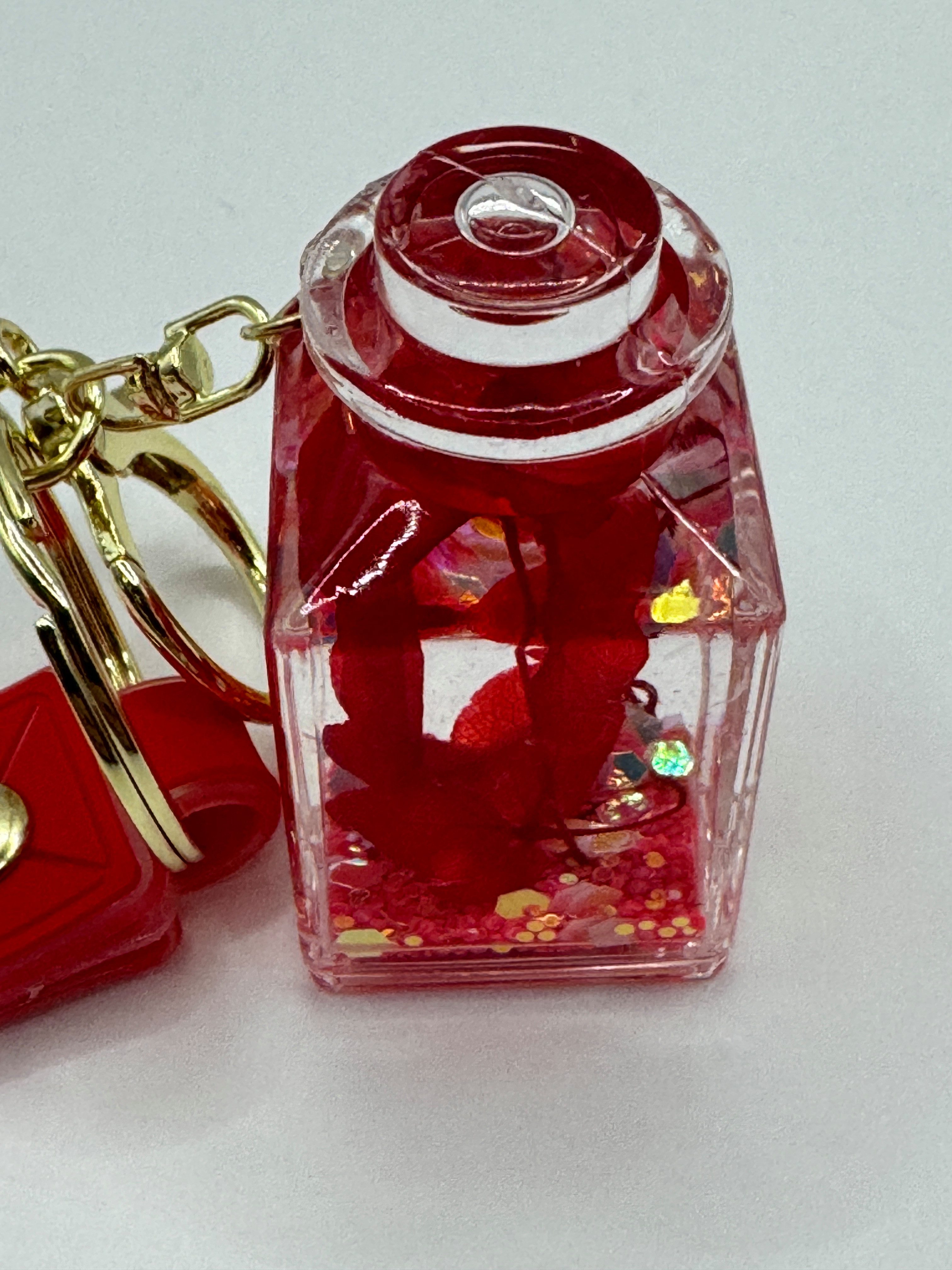Stelby Schlüsselanhänger Romantischer Flaschen-Schlüsselanhänger mit Blume & Glitzerdeko, Acryl-Fläschchen mit Kunstblume, Glitzer & stabilem Metallring