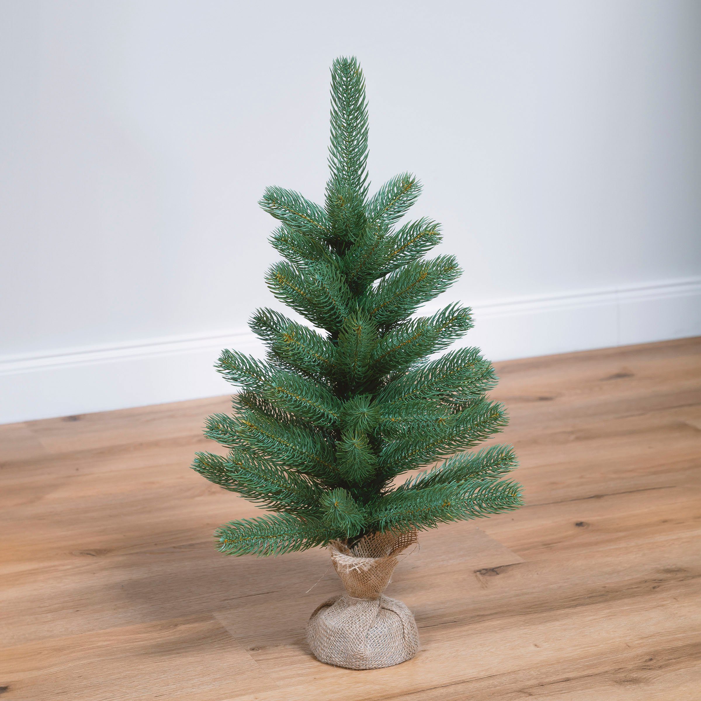 IC Winterworld Künstlicher Weihnachtsbaum Tannenbaum, künstlicher Christbaum, Nordmanntanne, Weihnachtsdeko mit Jutebeutel um den Betonfuß