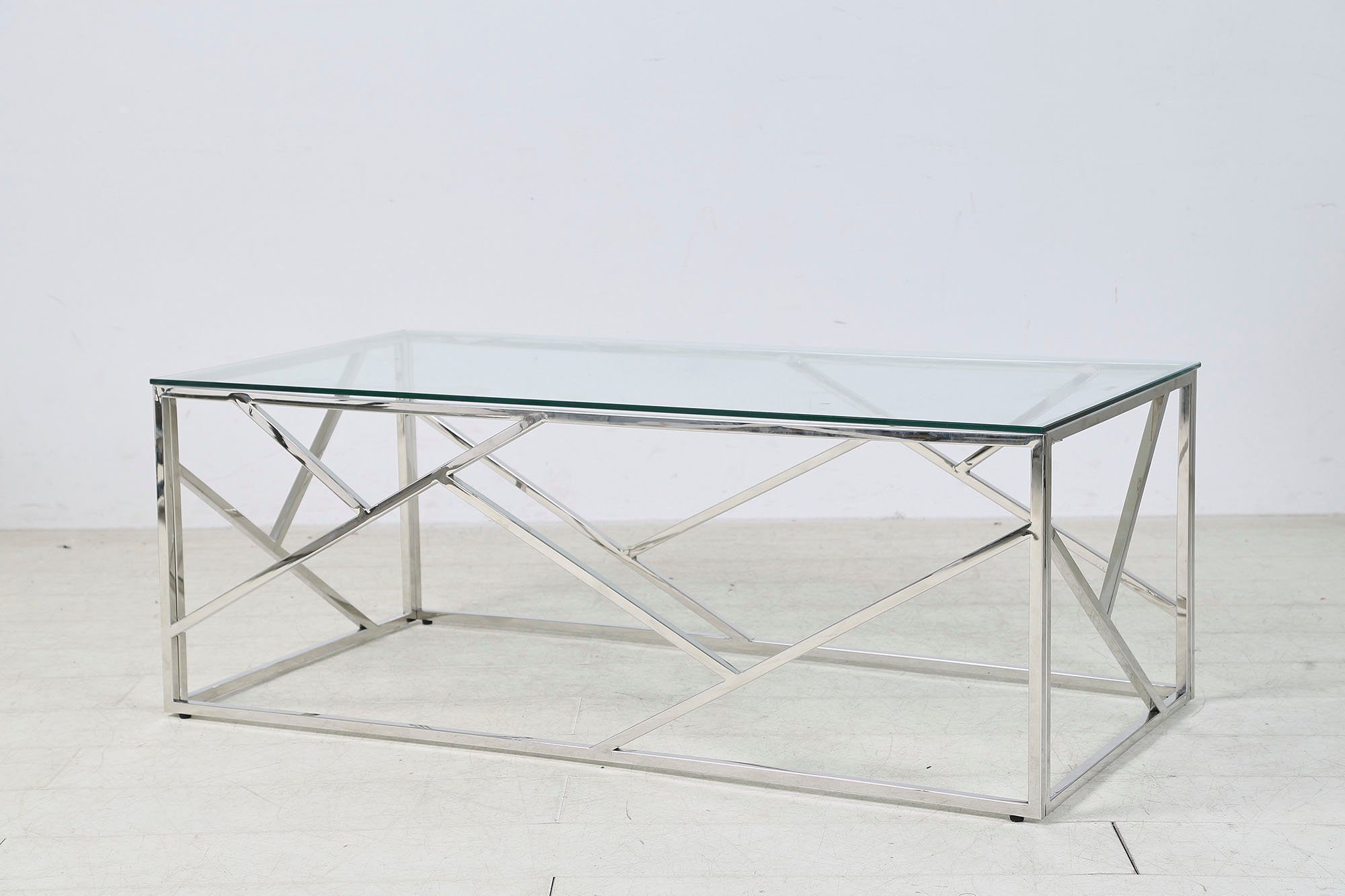Couchtisch, zum gefertigt Luxuriöser Glastisch im aus wird Gestell Edelstahl, rostfreiem SalesFever Sitzbereich Hingucker