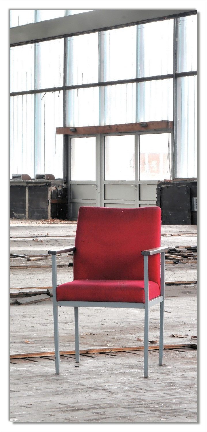 Wallario Türtapete Stille und Leere - ein einsamer roter Stuhl in einer alten Halle, glatt, ohne Struktur