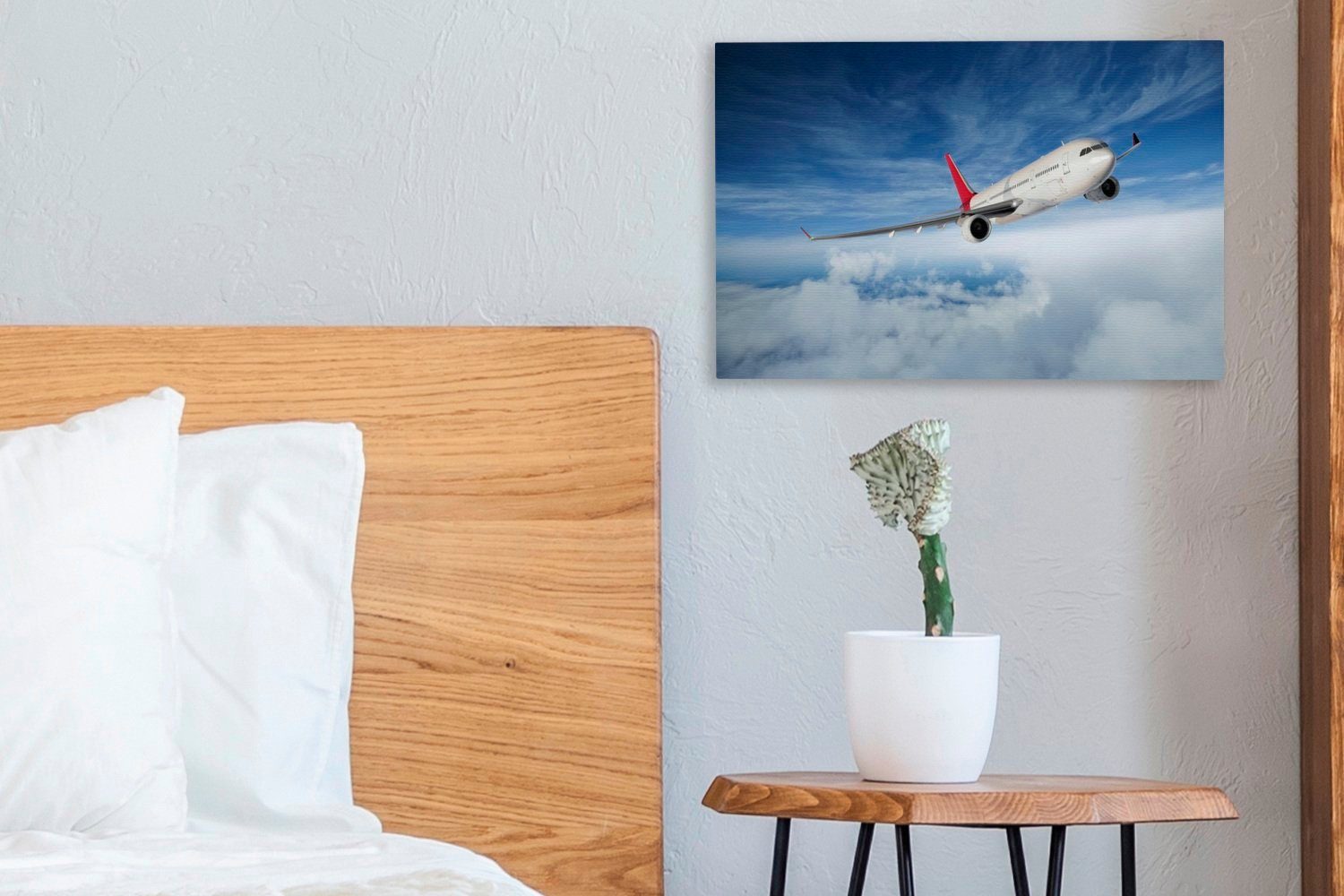 Eine OneMillionCanvasses® Himmel, Illustration Wanddeko, bei Leinwandbild St), cm (1 eines Wandbild Aufhängefertig, Leinwandbilder, bewölktem 30x20 Flugzeugs