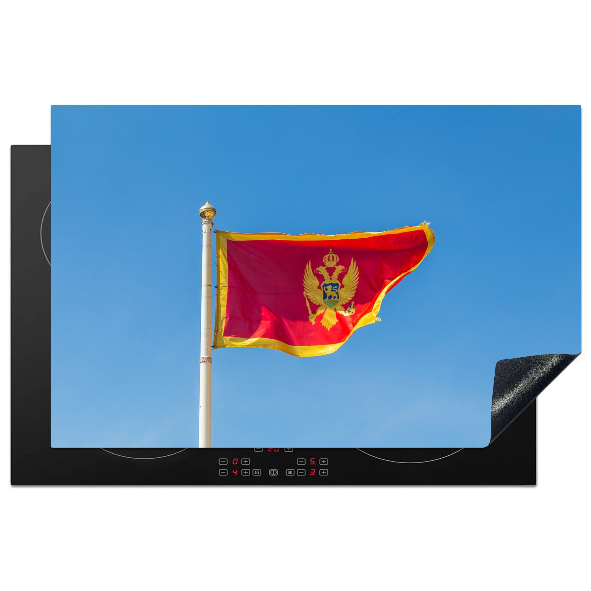 MuchoWow Herdblende-/Abdeckplatte Flagge von Montenegro vor einem klaren blauen Himmel, Vinyl, (1 tlg), 81x52 cm, Induktionskochfeld Schutz für die küche, Ceranfeldabdeckung