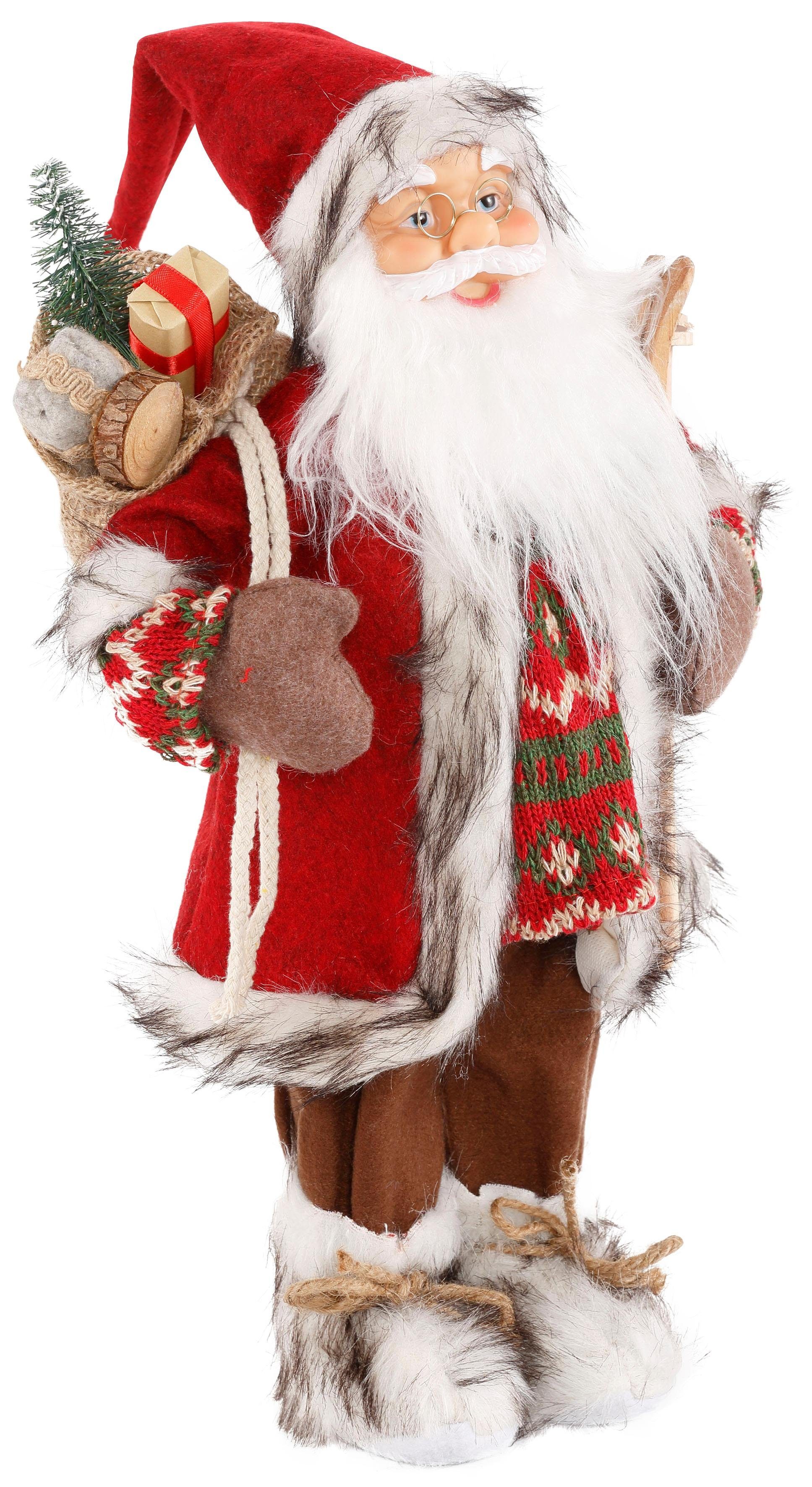 Santa Skiern - Weihnachtsfigur unter mit Weihnachtsmann und Weihnachtsdeko, HOMECOLLECTION dem Geschenken (1 St), Dekofigur, Arm HOSSNER