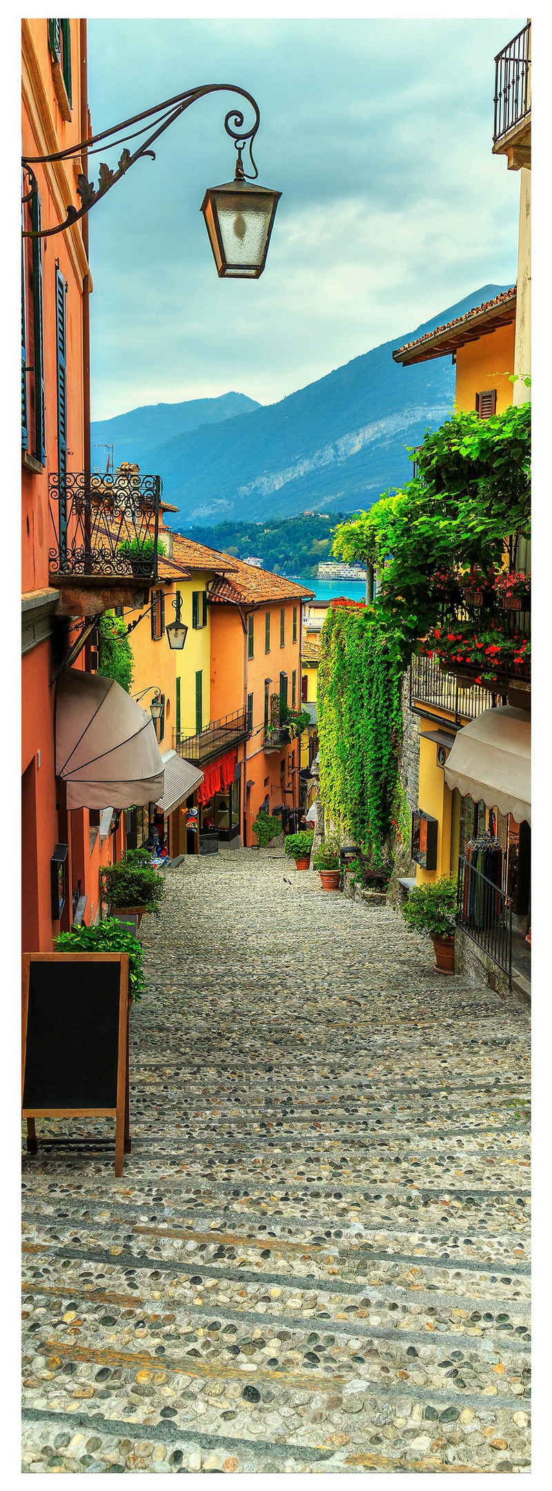 wandmotiv24 Türtapete Gasse mit Blick auf Berge & See, Italien, glatt, Fototapete, Wandtapete, Motivtapete, matt, selbstklebende Dekorfolie
