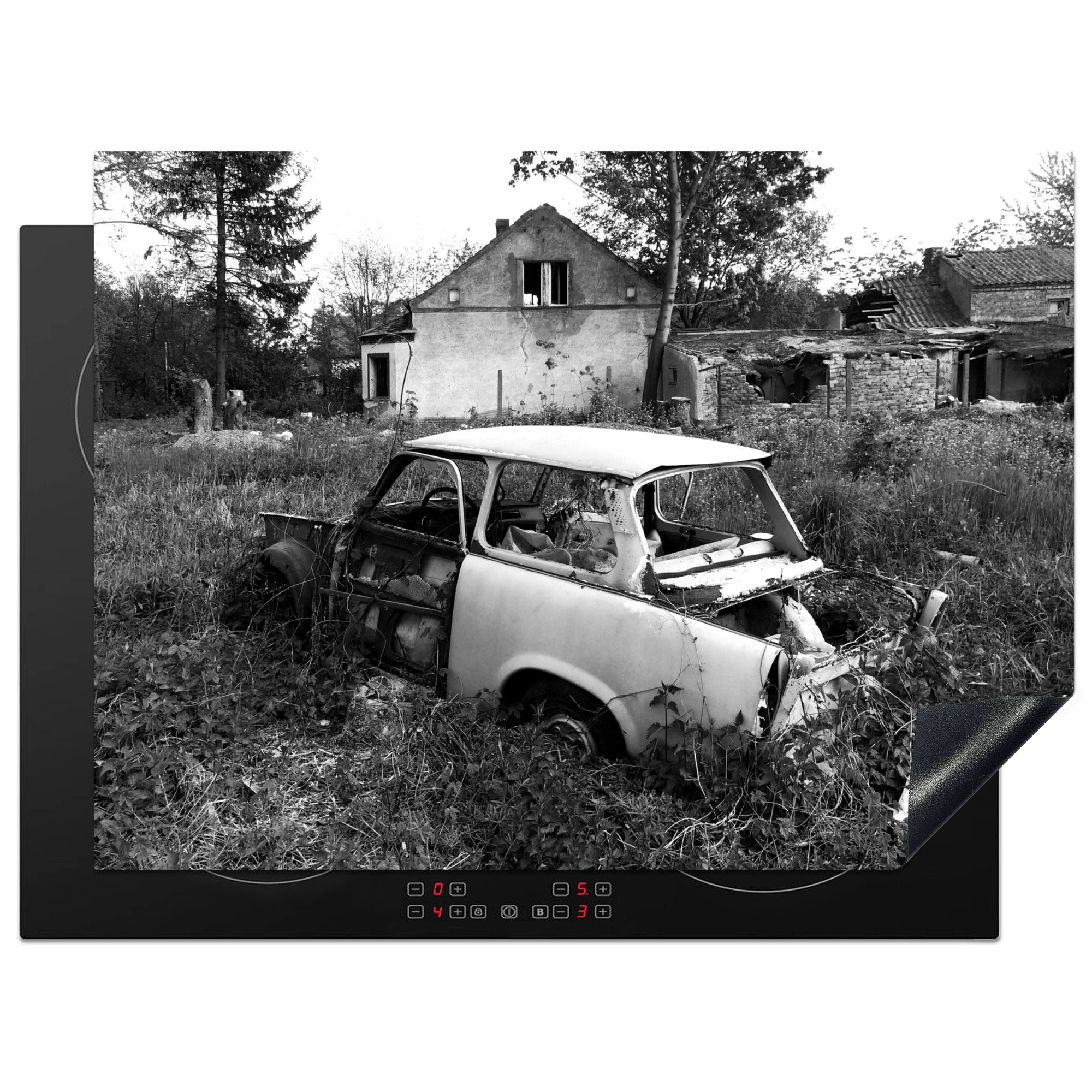 MuchoWow Herdblende-/Abdeckplatte Wrack eines Autos in der Nähe eines verlassenen Hauses - schwarz-weiß, Vinyl, (1 tlg), 70x52 cm, Mobile Arbeitsfläche nutzbar, Ceranfeldabdeckung | Herdabdeckplatten