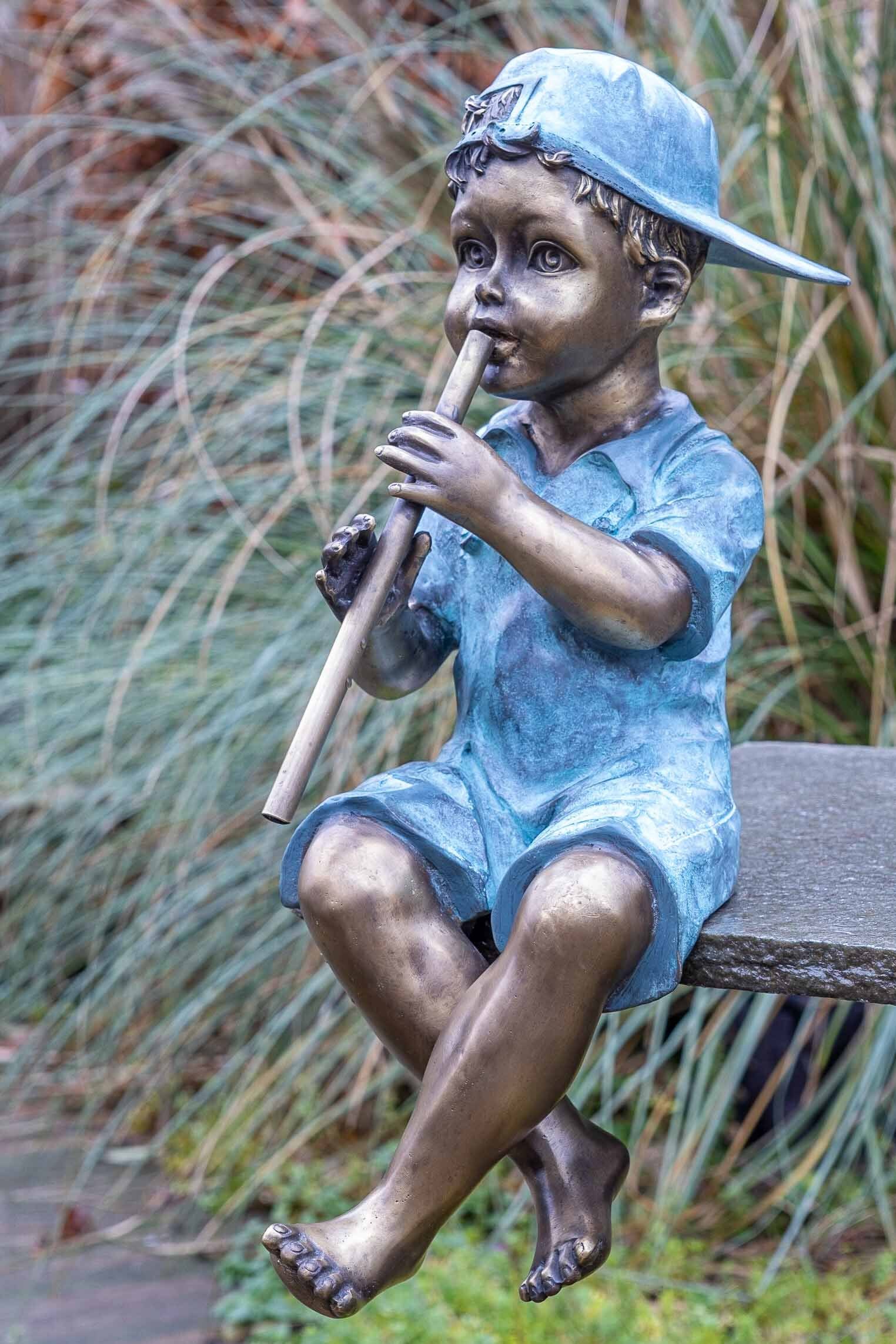 Bronze-Skulptur mit – Junge in sehr Bronze UV-Strahlung. einer IDYL Bronze Gartenfigur Regen gegossen und Die von Flöte, robust – Frost, Hand Langlebig IDYL witterungsbeständig Wachsausschmelzverfahren und werden patiniert. Modelle in – gegen