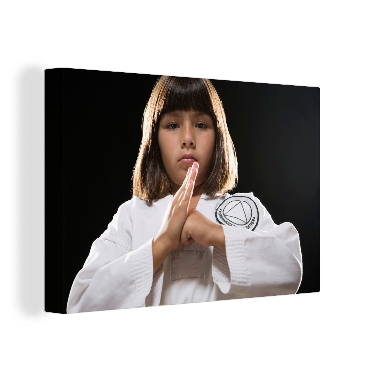 OneMillionCanvasses® Leinwandbild Ein Mädchen, das beim Karate mit der Hand auf die Handfläche schlägt, (1 St), Wandbild Leinwandbilder, Aufhängefertig, Wanddeko, 30x20 cm