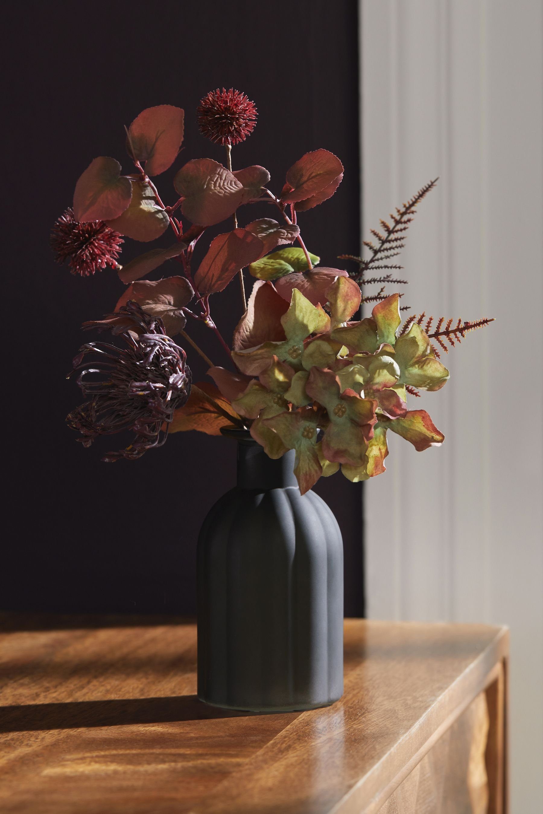 Vase, in matten, Next gerippten Kunstblumen einer Kunstblume