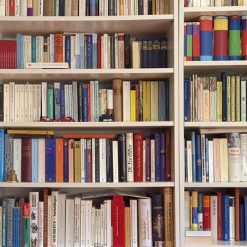 Wallario Möbelfolie Weißes Bücherregal mit unterschiedlichen Büchern