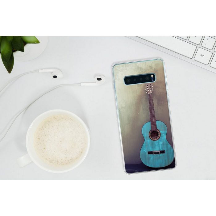 MuchoWow Handyhülle Farbige akustische Gitarre in einem Raum mit einer Betonwand Phone Case Handyhülle Samsung Galaxy S10+ Silikon Schutzhülle FN11389