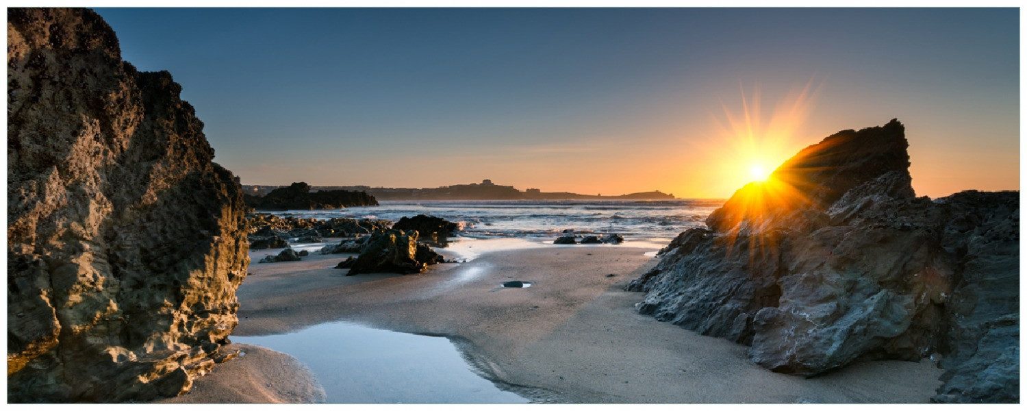 Wallario Memoboard Sonnenuntergang hinter einem Felsen am Strand