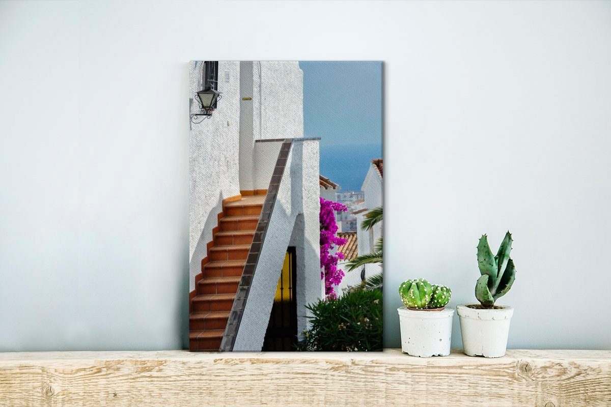 OneMillionCanvasses® Leinwandbild Ein Blick St), zwischen weißen Gemälde, den auf 20x30 cm Leinwandbild Häusern Meer (1 bespannt Spaniens, Zackenaufhänger, fertig das inkl