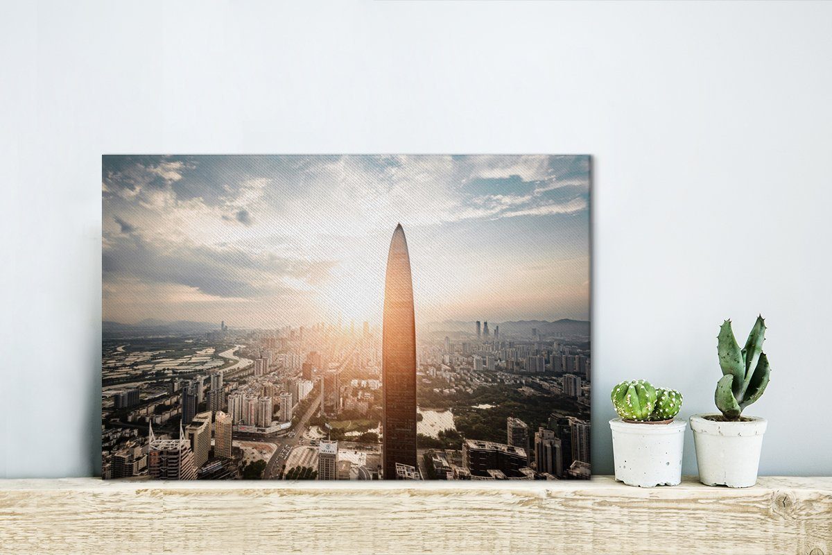 Leinwandbild St), den (1 Wanddeko, Wandbild cm in Leinwandbilder, Shenzhen an scheinen OneMillionCanvasses® Aufhängefertig, 30x20 Gebäuden Sonnenstrahlen Die vorbei,