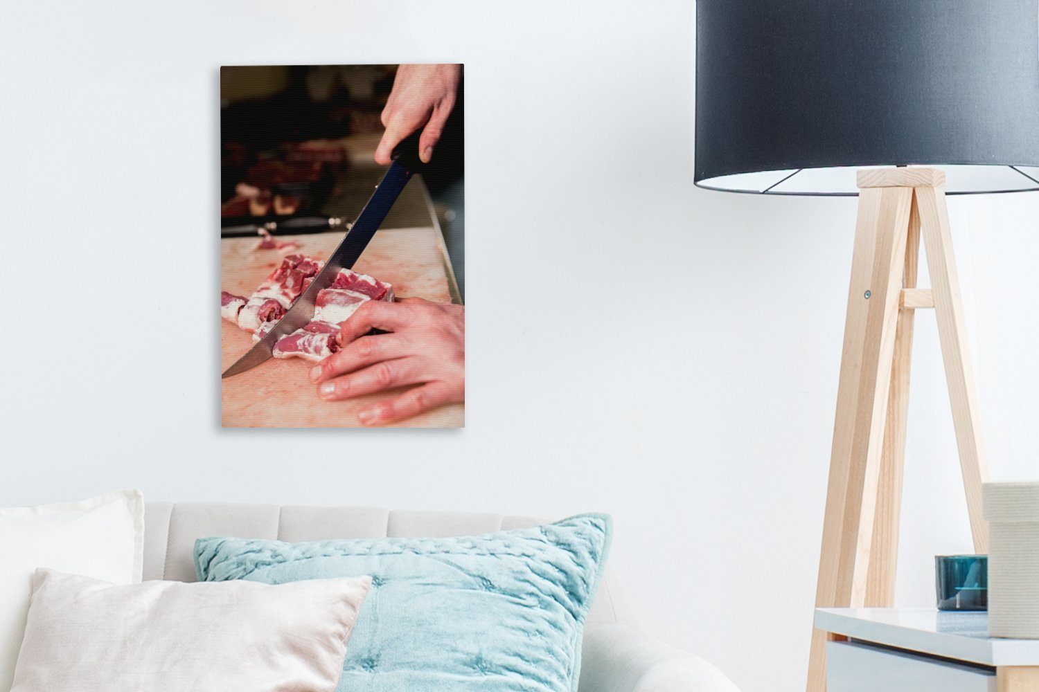OneMillionCanvasses® Leinwandbild Ein Fleischer schneidet das Zackenaufhänger, inkl. einem Leinwandbild Gemälde, 20x30 Messer, (1 mit fertig Fleisch cm St), bespannt