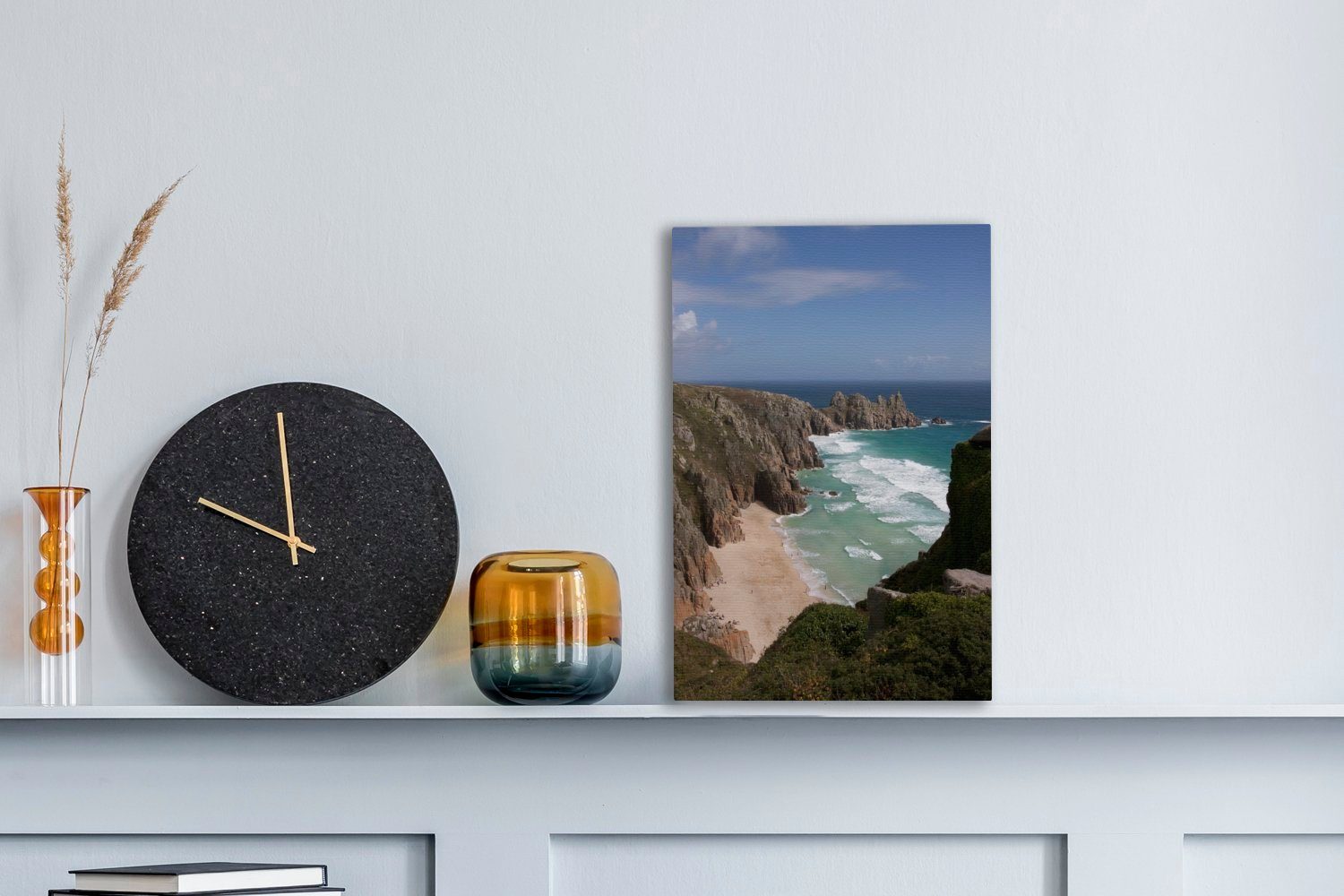 OneMillionCanvasses® Leinwandbild Eine steile und inkl. Cornwall, (1 dem fertig Klippe weitläufige Leinwandbild Gemälde, Zackenaufhänger, Strand 20x30 cm von bespannt St), vor