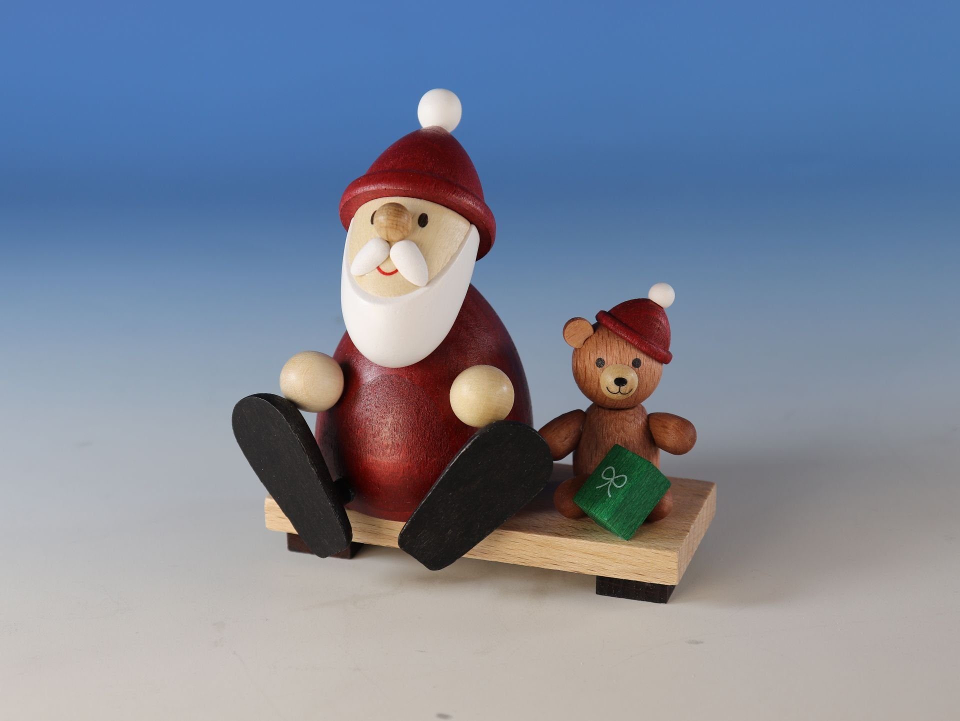 Ullrich Kunsthandwerk Weihnachtsmann Geschenkset Weihnachtsmann mit Teddy auf Bank Dekofigur, in Klarsicht Geschenkbox