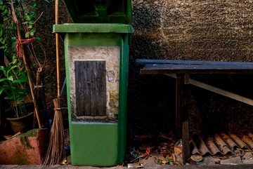 MuchoWow Wandsticker Eine alte Holztür in der Nähe einer alten Mauer in der italienischen (1 St), Mülleimer-aufkleber, Mülltonne, Sticker, Container, Abfalbehälter
